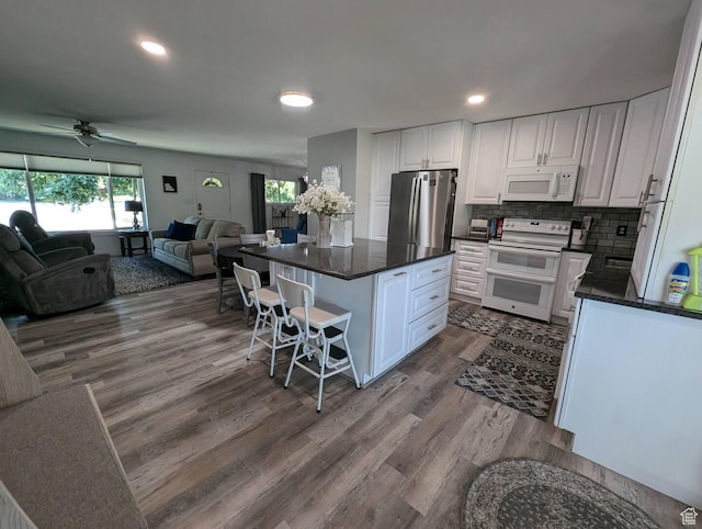 1704 S Sorrento Dr, Woods Cross, UT 84087 - kitchen featuring white appliances, open floor plan, white cabinetry, a kitchen bar, and dark wood-style flooring