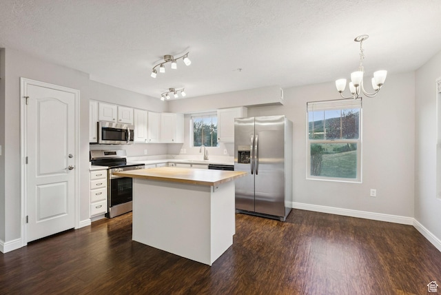 1729 Fox Bay Dr Unit J104, Heber City, UT 84032 - kitchen featuring appliances with stainless steel finishes, dark wood-style floors, a chandelier, and white cabinetry