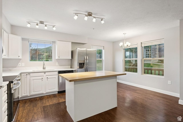 1729 Fox Bay Dr Unit J104, Heber City, UT 84032 - kitchen featuring appliances with stainless steel finishes, wooden counters, a chandelier, white cabinetry, and dark wood-style flooring
