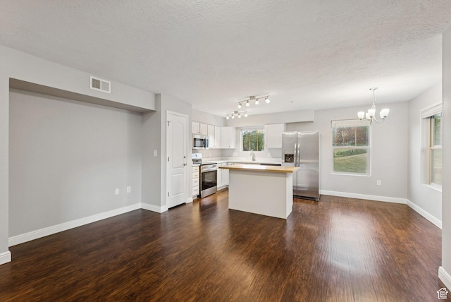 1729 Fox Bay Dr Unit J104, Heber City, UT 84032 - kitchen featuring stainless steel appliances, a chandelier, dark wood finished floors, light countertops, and a textured ceiling