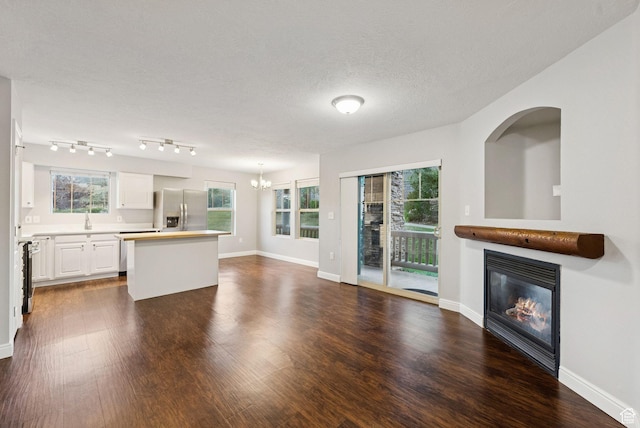 1729 Fox Bay Dr Unit J104, Heber City, UT 84032 - unfurnished living room with a glass covered fireplace, a chandelier, dark wood-style floors, and a textured ceiling