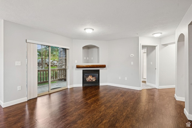 1729 Fox Bay Dr Unit J104, Heber City, UT 84032 - unfurnished living room featuring wood finished floors, a glass covered fireplace, and a textured ceiling