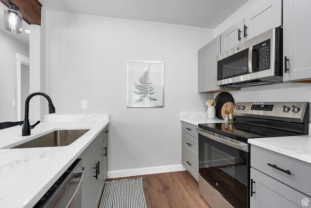 482 N Brook Ave E, Tooele, UT 84074 - kitchen featuring stainless steel appliances, dark wood-type flooring, light stone counters, and gray cabinetry