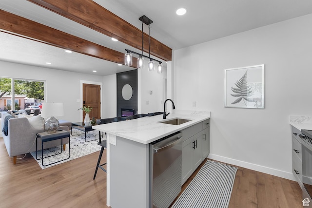 482 N Brook Ave E, Tooele, UT 84074 - kitchen featuring dishwasher, open floor plan, light wood-type flooring, a peninsula, and a breakfast bar area