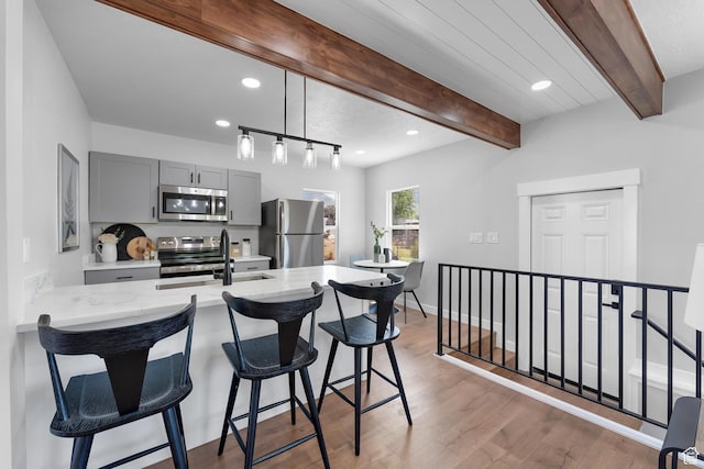 482 N Brook Ave E, Tooele, UT 84074 - kitchen featuring stainless steel appliances, gray cabinetry, a kitchen breakfast bar, recessed lighting, and light wood finished floors