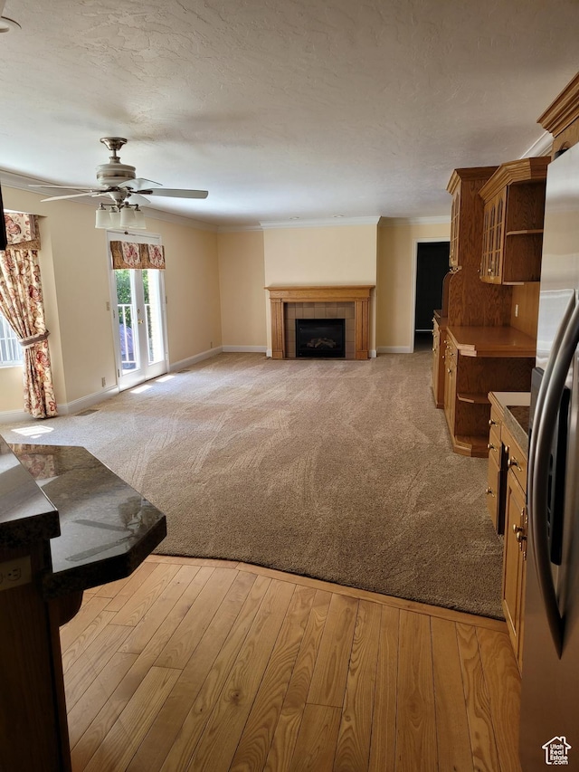 1360 Lakeview Dr, Bountiful, UT 84010 - unfurnished living room with light colored carpet, a ceiling fan, crown molding, and a tiled fireplace