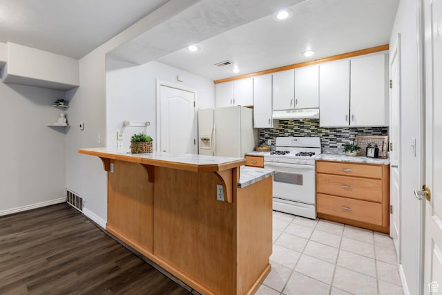 4072 S 300 E Unit 8, Salt Lake City, UT 84107 - kitchen with white appliances, under cabinet range hood, a peninsula, a breakfast bar area, and light countertops
