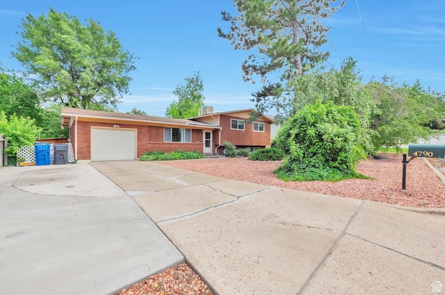 4790 Burch Dr, South Ogden, UT 84403 - split level home with an attached garage, driveway, and brick siding