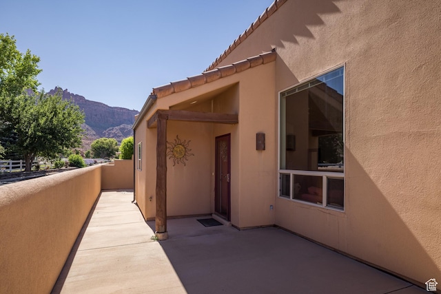 3686 S Spanish Valley Dr Unit N-2, Moab, UT 84532 - view of exterior entry with stucco siding, a mountain view, and a patio