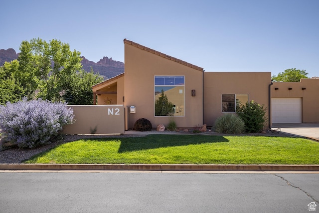 3686 S Spanish Valley Dr Unit N-2, Moab, UT 84532 - view of front of property with a garage, stucco siding, a mountain view, a front yard, and concrete driveway
