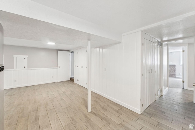 2353 E Logan Cir, Salt Lake City, UT 84108 - finished basement featuring wood finished floors, a textured ceiling, and a decorative wall