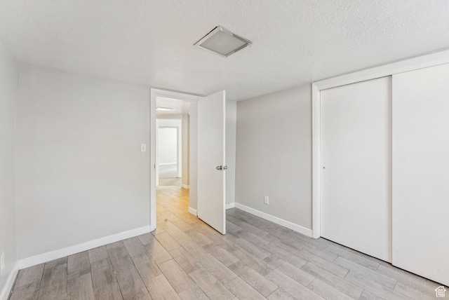 2353 E Logan Cir, Salt Lake City, UT 84108 - unfurnished bedroom with light wood-style floors, a textured ceiling, and a closet