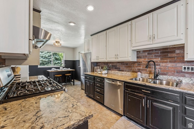 2353 E Logan Cir, Salt Lake City, UT 84108 - kitchen featuring stainless steel appliances, white cabinets, dark cabinetry, decorative backsplash, and a textured ceiling