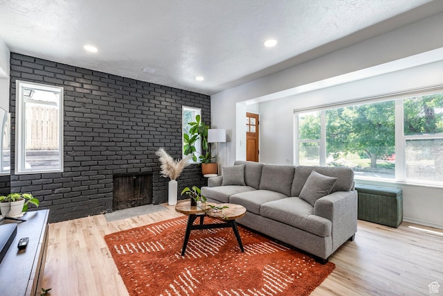 2605 E Simpson Ave, Salt Lake City, UT 84109 - living area with wood finished floors, a fireplace, brick wall, and recessed lighting