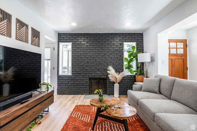 2605 E Simpson Ave, Salt Lake City, UT 84109 - living room with a fireplace, light wood finished floors, brick wall, and recessed lighting