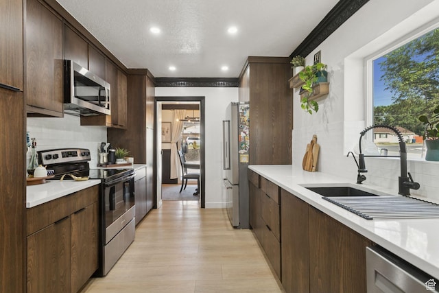 175 Grove Creek Dr N, Pleasant Grove, UT 84062 - kitchen featuring appliances with stainless steel finishes, backsplash, light countertops, dark brown cabinets, and recessed lighting