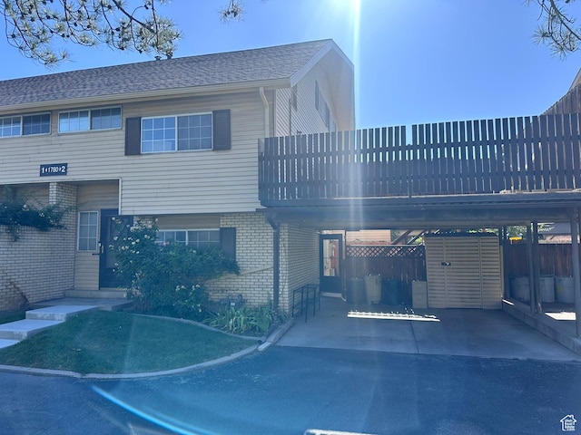 1780 W Homestead Farms Ln S Unit 2, West Valley City, UT 84119 - view of front of property with brick siding, a carport, and driveway