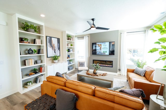 11378 S Aqua St W Unit 229, South Jordan, UT 84009 - living area featuring wood finished floors, plenty of natural light, ceiling fan, recessed lighting, and a glass covered fireplace