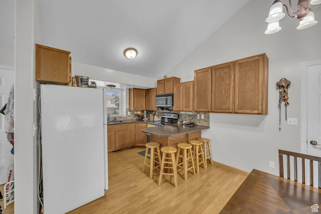 3820 Foxglen Dr, Roy, UT 84067 - kitchen with black microwave, freestanding refrigerator, stainless steel range with electric stovetop, a peninsula, and a chandelier