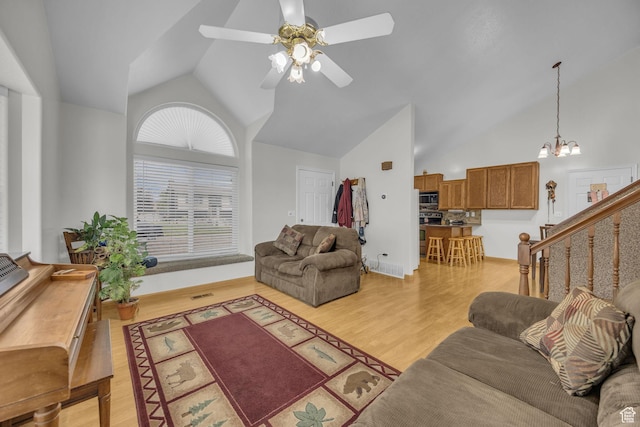 3820 Foxglen Dr, Roy, UT 84067 - living area featuring a ceiling fan, light wood-style floors, a chandelier, and high vaulted ceiling