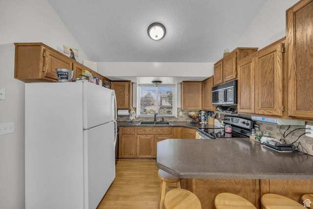 3820 Foxglen Dr, Roy, UT 84067 - kitchen with freestanding refrigerator, stainless steel electric range, black microwave, a peninsula, and dark countertops