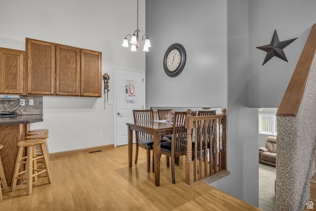 3820 Foxglen Dr, Roy, UT 84067 - dining room with a high ceiling, light wood-style floors, and a chandelier