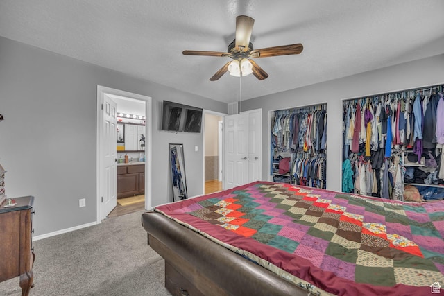 3820 Foxglen Dr, Roy, UT 84067 - carpeted bedroom featuring multiple closets, ensuite bathroom, ceiling fan, and a textured ceiling