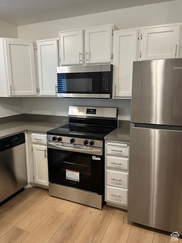 1455 N Amiron Way Unit A, Orem, UT 84057 - kitchen featuring stainless steel appliances, white cabinetry, light wood-style flooring, and dark countertops