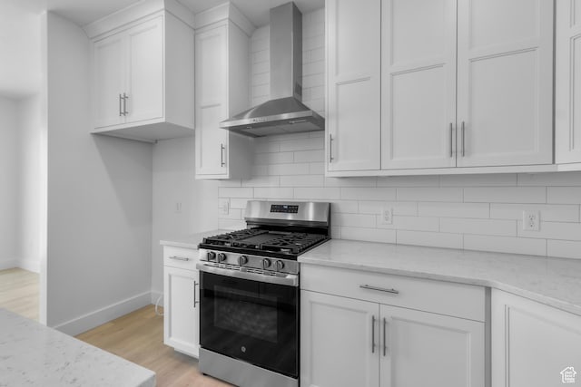 201 E 580 N, Providence, UT 84332 - kitchen with stainless steel range with gas stovetop, wall chimney exhaust hood, light wood finished floors, white cabinetry, and backsplash