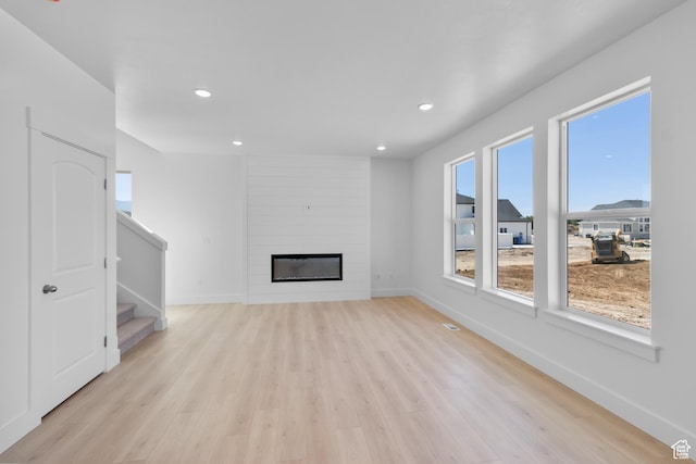 201 E 580 N, Providence, UT 84332 - unfurnished living room featuring light wood-style floors, stairs, recessed lighting, and a fireplace
