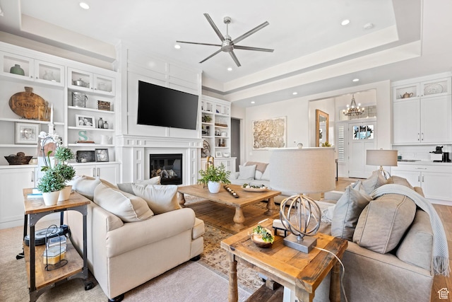 2918 E Willow Tree Ln, St George, UT 84790 - living room with ceiling fan, a chandelier, a glass covered fireplace, recessed lighting, and built in features