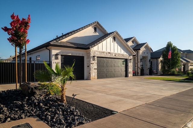 2918 E Willow Tree Ln, St George, UT 84790 - view of front of house featuring a garage, a tiled roof, board and batten siding, driveway, and stone siding
