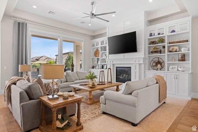 2918 E Willow Tree Ln, St George, UT 84790 - living area with a ceiling fan, light wood finished floors, a glass covered fireplace, recessed lighting, and built in shelves