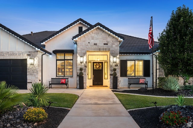 2918 E Willow Tree Ln, St George, UT 84790 - view of front of house featuring stone siding, stucco siding, covered porch, and an attached garage