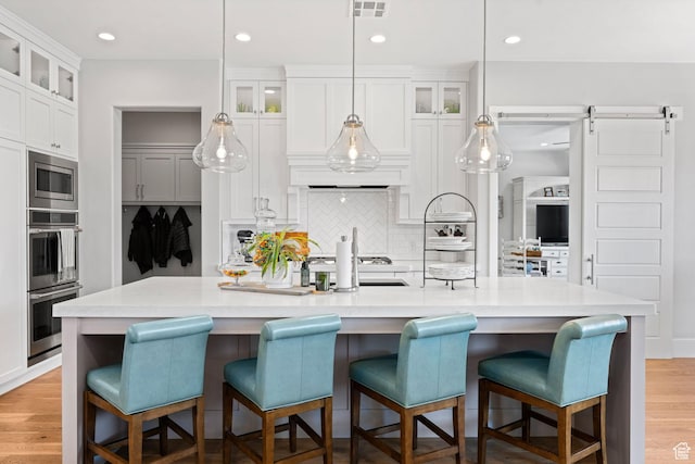 2918 E Willow Tree Ln, St George, UT 84790 - kitchen with appliances with stainless steel finishes, backsplash, light countertops, white cabinets, and glass insert cabinets