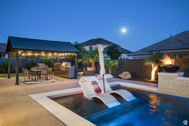 2918 E Willow Tree Ln, St George, UT 84790 - fenced backyard with a gazebo, an outdoor fire pit, exterior kitchen, a patio, and outdoor dining space
