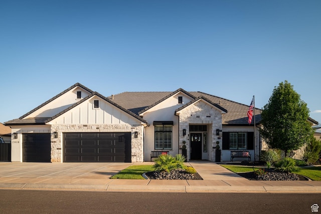 2918 E Willow Tree Ln, St George, UT 84790 - view of front facade with a garage, driveway, stone siding, board and batten siding, and a tile roof