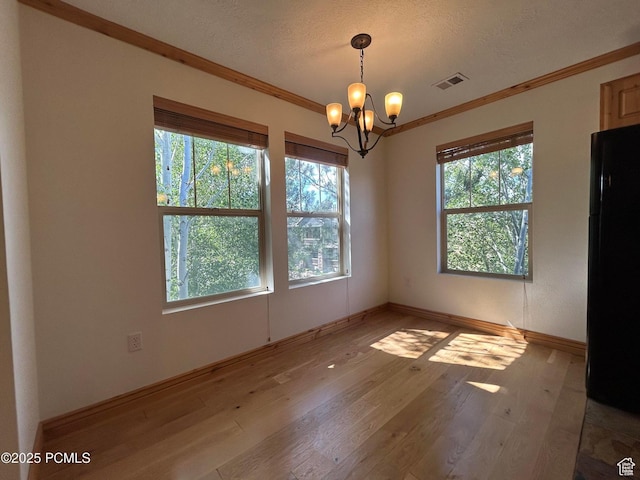 1729 Fox Bay Dr Unit J201, Heber City, UT 84032 - unfurnished dining area with healthy amount of natural light, a chandelier, hardwood / wood-style flooring, ornamental molding, and a textured ceiling