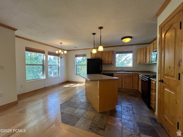 1729 Fox Bay Dr Unit J201, Heber City, UT 84032 - kitchen with black appliances, crown molding, plenty of natural light, a kitchen island, and stone tile flooring