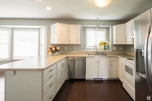 373 S 3240 W, Vernal, UT 84078 - kitchen with appliances with stainless steel finishes, a peninsula, dark wood-style flooring, light countertops, and white cabinetry