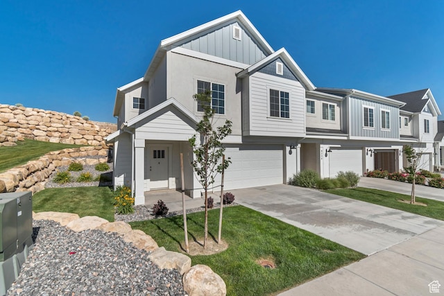 9728 N Aaron Ave Unit 115, Eagle Mountain, UT 84005 - view of front facade with board and batten siding, a garage, concrete driveway, and a front lawn