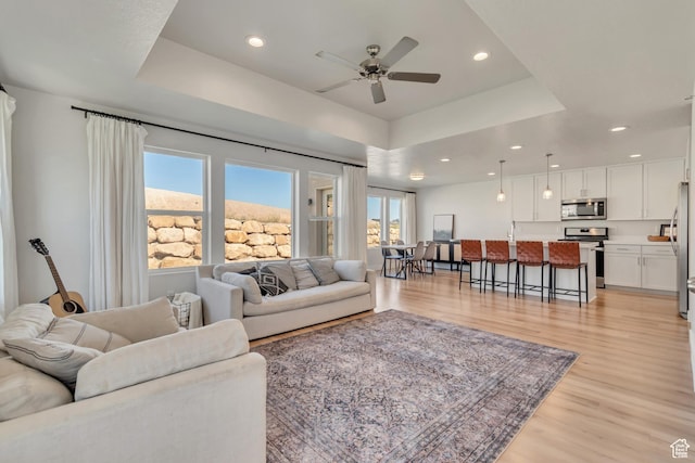 9728 N Aaron Ave Unit 115, Eagle Mountain, UT 84005 - living room featuring a raised ceiling, light wood-type flooring, ceiling fan, and recessed lighting