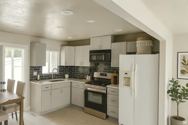 1540 S 900 W, Salt Lake City, UT 84104 - kitchen featuring white refrigerator with ice dispenser, black microwave, stainless steel stove, light countertops, and backsplash