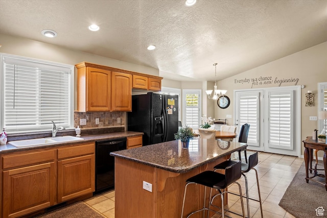 2265 N 515 E, North Ogden, UT 84414 - kitchen with black appliances, a breakfast bar, a center island, a chandelier, and a textured ceiling