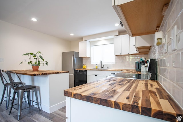129 N 100 E, Ephraim, UT 84627 - kitchen with butcher block counters, dishwasher, freestanding refrigerator, wood finished floors, and a breakfast bar