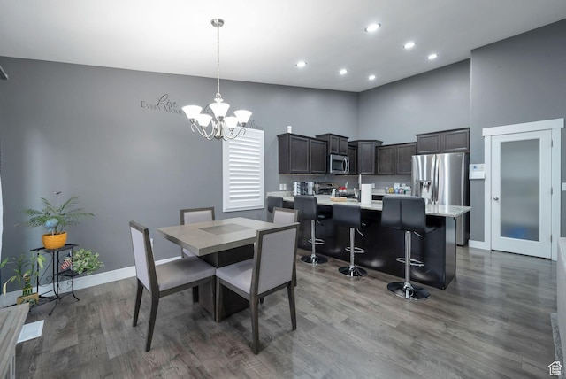 5198 W Courtly Ln, Herriman, UT 84096 - dining area with wood finished floors, a chandelier, recessed lighting, and a high ceiling