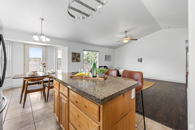 6228 S Waller Ln, West Jordan, UT 84081 - kitchen featuring vaulted ceiling, a center island, ceiling fan, a breakfast bar area, and a chandelier