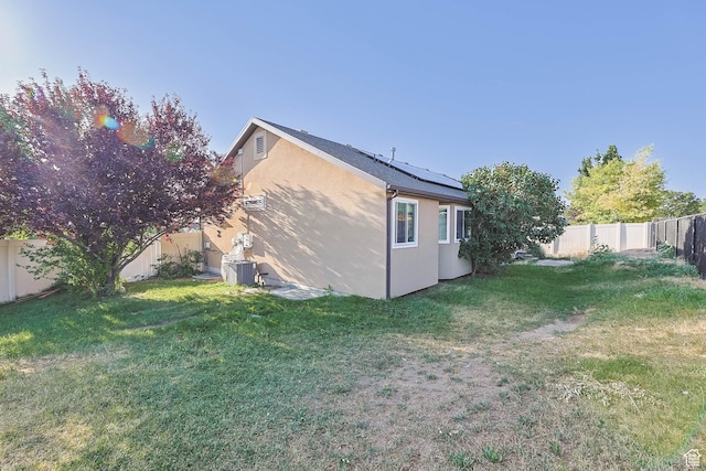 6228 S Waller Ln, West Jordan, UT 84081 - view of property exterior featuring stucco siding, roof mounted solar panels, and a fenced backyard