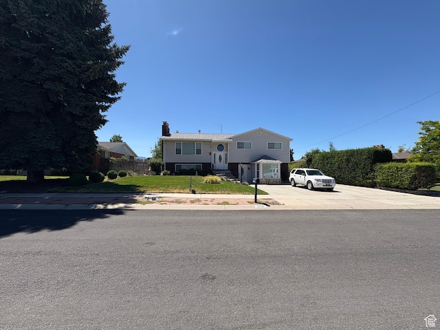 4208 S 4205 W, West Valley City, UT 84120 - raised ranch featuring a chimney, a front yard, and concrete driveway