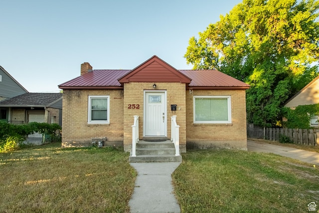 252 E 1000 N, Logan, UT 84321 - bungalow featuring a chimney, brick siding, and a metal roof